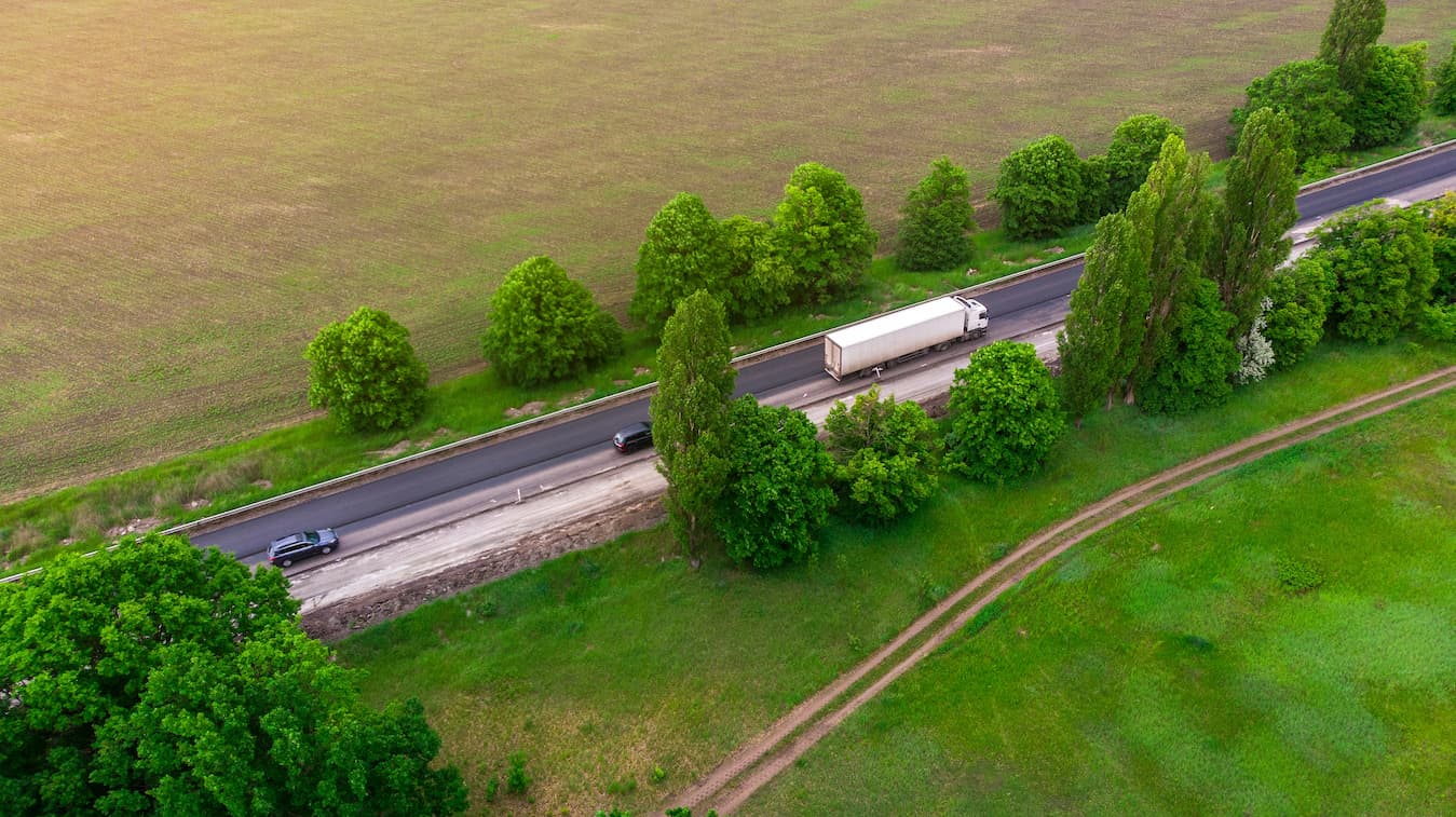 LKW aus der Luft auf Ukrainischer Landstraße Wald Bäume